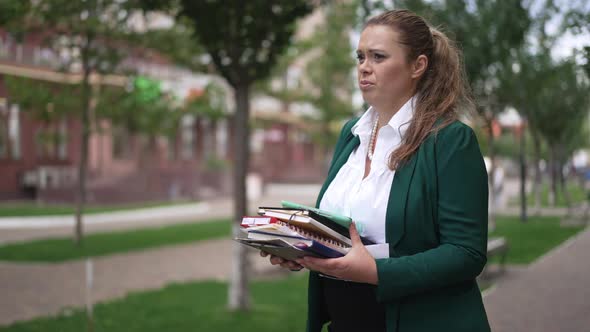Overwhelmed Caucasian Obese Businesswoman Standing on Sidewalk with Paperwork Looking Around alt