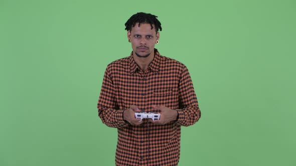 Happy Young Handsome African Man Playing Games and Winning alt