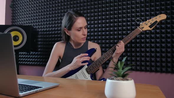 Teenager Female Learning Play Guitar at Home Using Online Lessons alt