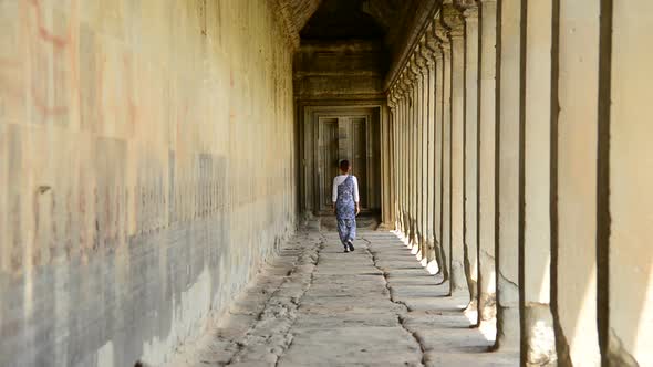 Female Buddhist Slowly Walking Down Temple Hallway  - Angkor Wat Temple Cambodia