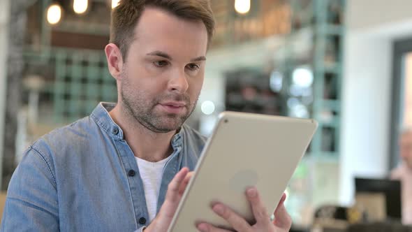 Portrait of Attractive Casual Man Using Digital Tablet alt
