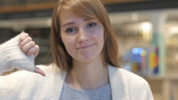 Thumbs Down by Young Woman in Cafe alt