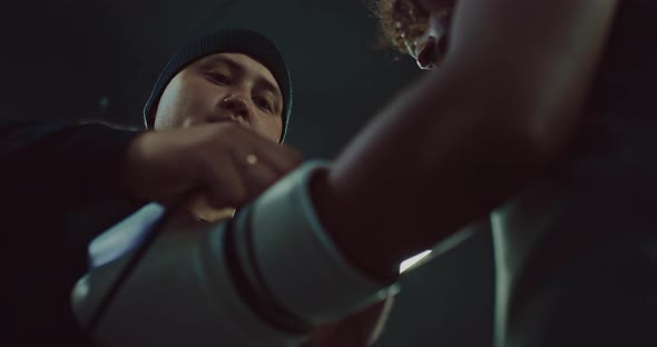 Professional Coach is Helping Black Fighter to Put Gloves Before Fight Closeup  Prores alt