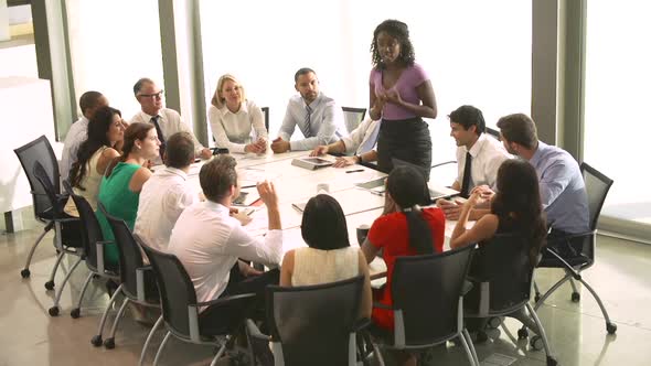 Businesswoman Addressing Meeting Around Boardroom Table 3 alt