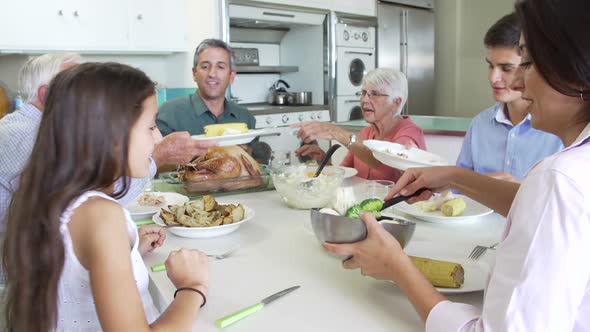 Multi-Generation Family Sitting Around Table Eating Meal alt