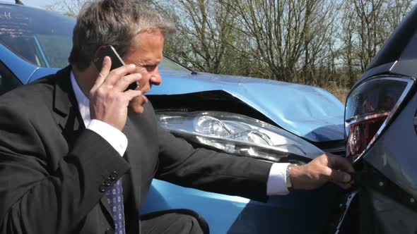 Businessman Making Phone Call After Traffic Accident