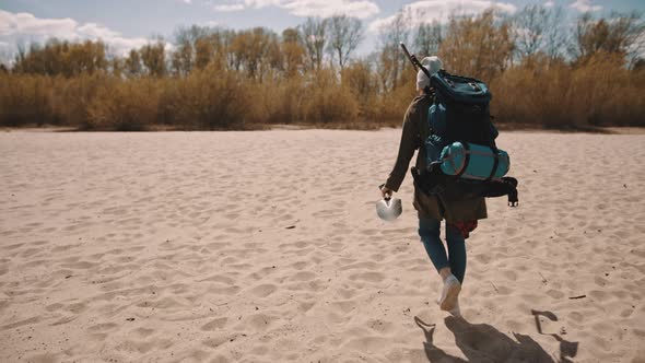 Explorer with the Backpack, Shoevel and Metal Detectar Walking on the Sandy Beach. Searching for the alt