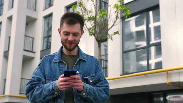 Handsome Bearded Caucasian Man Using Mobile Phone alt