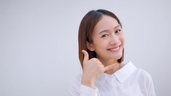 Asian girls willing to make phone gestures pretend to communicate on mobile phone