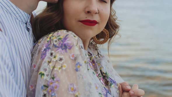 Closeup of Couple in Love Hugs Refocus the Guy Hugs the Girl From Behind Hold Hands Woman with alt