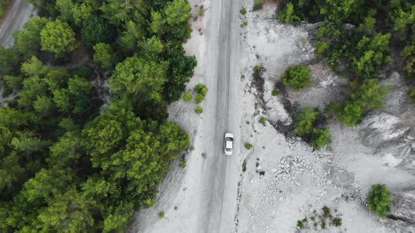 Aerial landscape. Fly over mountain road with car. Lateral top view alt