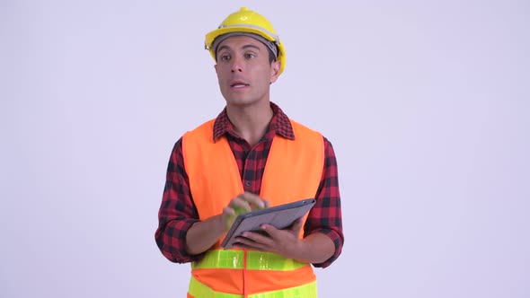 Young Happy Hispanic Man Construction Worker Talking While Using Digital Tablet