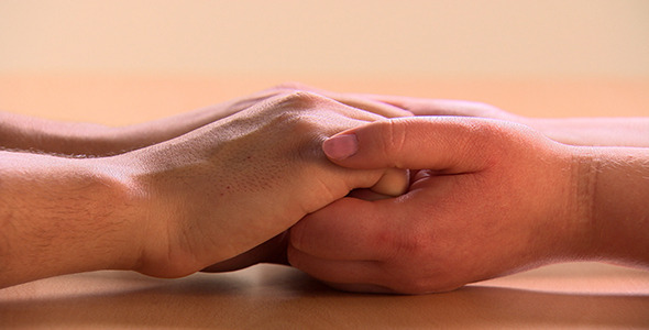 Man and Woman Holding Hands on Tabletop