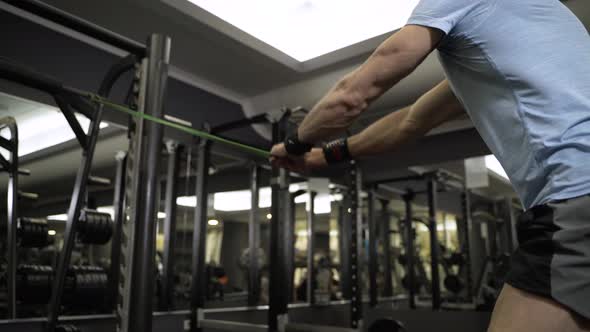 Close up image of man doing exercise with elastic band at the gym. alt
