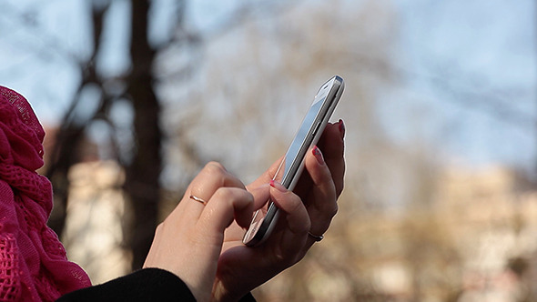 Girl's Fingers Typing On A Mobile Phone alt