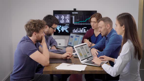 Creative Business. A Team of Developers and Designers Discussing the Layout of a Mobile Application alt