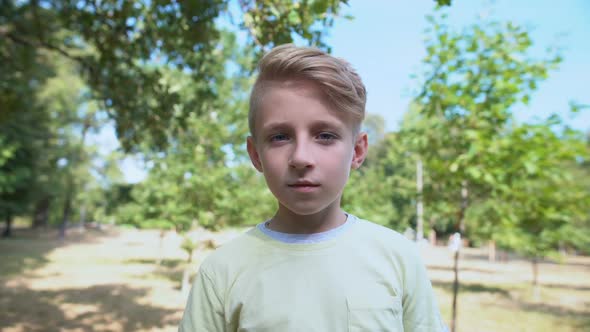 Surprised Caucasian Boy Feeling Shocked Standing in Park, Emotions Concept