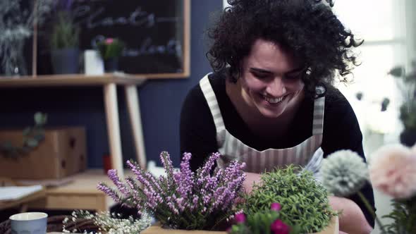 Florist enjoying the smell of blooming flowers alt
