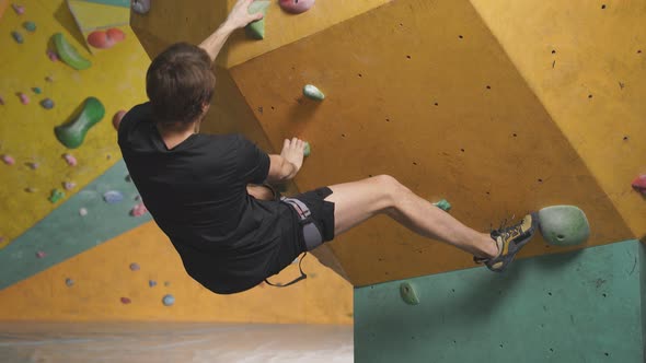 Strong Man Practicing Climbing on Artificial Rock Wall