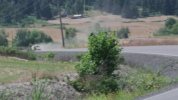 Tracking shot of man riding motorcycle on country road.  Fully released for commercial use.