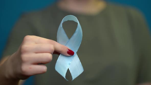 World Diabetes Day. Blue Ribbon Symbolic Isolated with Hand Support alt