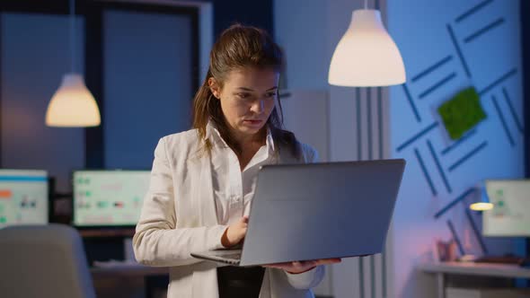 Focused Businesswoman Checking Company Reports Standing in Start Up Office alt