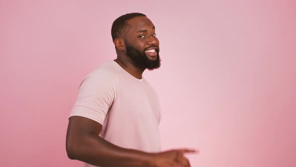 Profile Portrait of Black Man Turning to Camera and Indicating Happily at Camera Choosing Pink alt