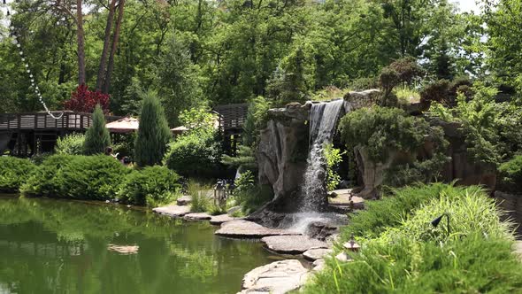 small waterfall near lake with stones in summer