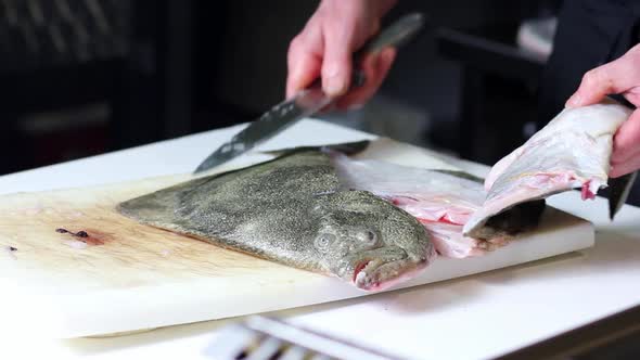 Raw turbot fish getting cleaned up and cut in fillet at a fish a fish vendor establishment alt
