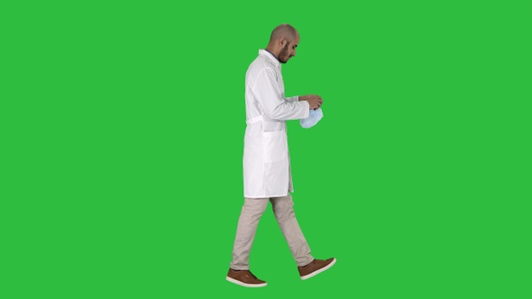 Arabic doctor walking and putting medical cap on on a Green alt