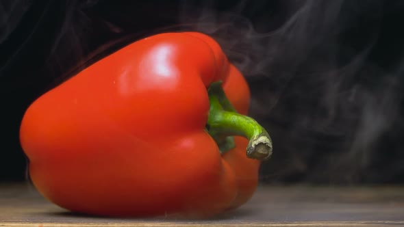 Sweet Red Bell Pepper or Capsicum Is on the Table in Cold, Steam From Frost in Slow Motion alt