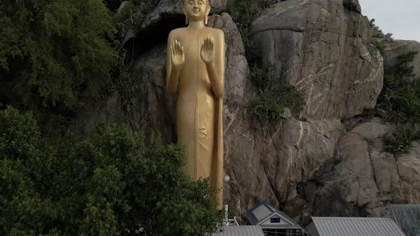 Ascending view of Golden Buddha Statue standing on Rock formation at seaside, Hua Hin alt