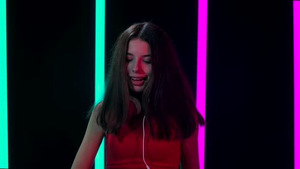 Portrait of a Young Pretty Woman in Big Red Headphones Looks Into the Camera, Dances, Sings and alt