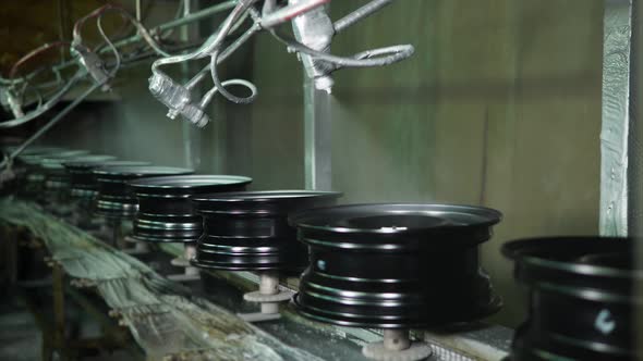 Robotic Painting Machines Are Spraying Metallic Paints Over Steel Wheels. alt