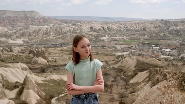 Girl Crossing Hands and Winking in Scenic Valley alt