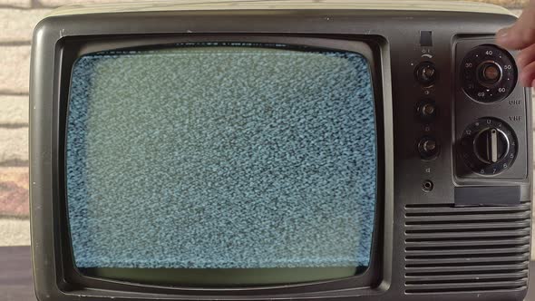 A Hand Is Seaching For A Channel On An Old Tv Camera Zooming Out 1 alt