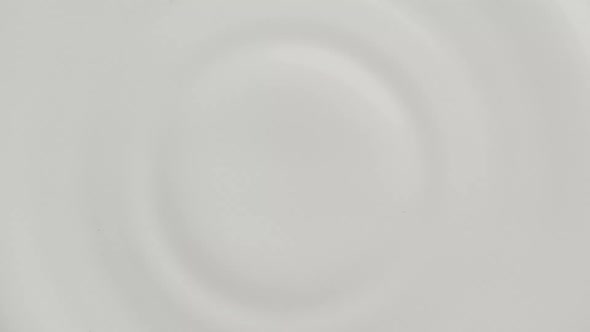 Milk Drop Dripping on the White Liquid Surface Making Crown and Circular Ripples alt