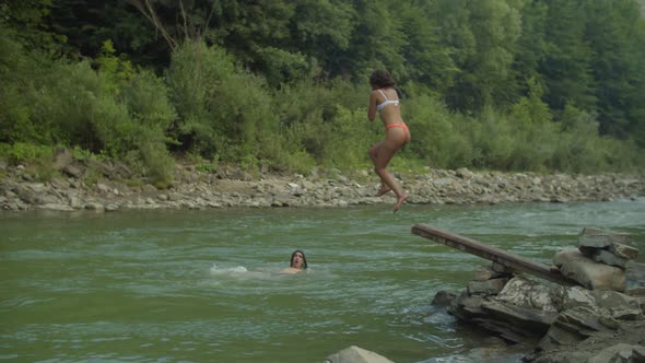 Carefree Diverse Multicultural People Diving Into Mountain River Off Springboard alt