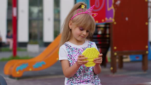 Child Girl Kid Playing Squeezing Antistress Pop It Toys Simple Dimple Squishy Game on Playground alt