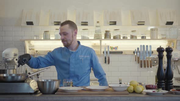 Professional Confident Chef Cooker in Black Gloves Friyng or Stewing Slices of Zucchini and Corn on alt