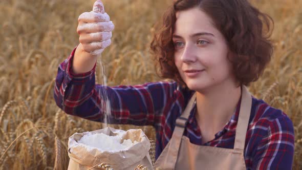 Close Up Of Happy Woman Pouring Flour In Wheat Field. Organic Flour Production, Organic Agricultural alt