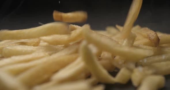 French fries with salt close up slow motion studio, tasty fast food
