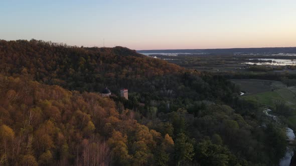 Slow view around mountain at sunset in autumn with church tucked into the forest on the mountain.