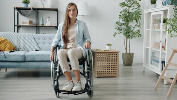 Slow Motion Portrait of Beautiful Paraplegic Lady Sitting in Wheelchair in Modern Room alt