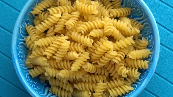Fusilli pasta on blue background