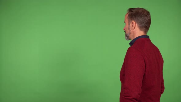 A Middleaged Handsome Caucasian Man Looks at the Green Screen Background