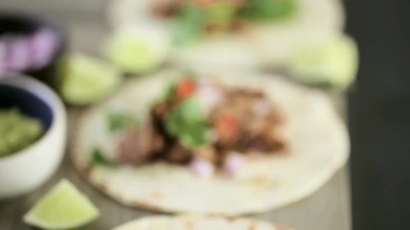 Close up of pulled pork carnitas with pico de gallo on a flour tortilla. alt