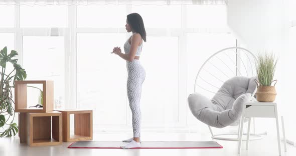 Athletic fit black woman doing fitness aerobic exercises for booty in living room.