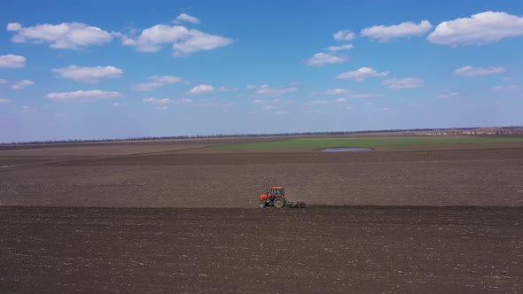Red Tractor and Plow Aerial Landscape View alt