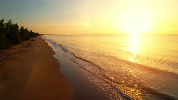 An aerial view of a drone flying over a sandy beach alt
